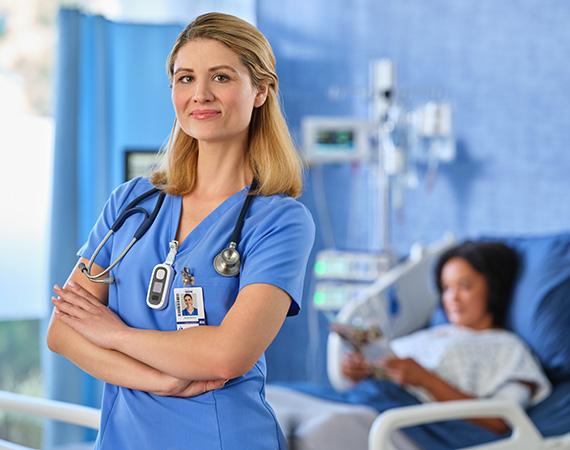 a nurse smiles confidently in a hospital room setting